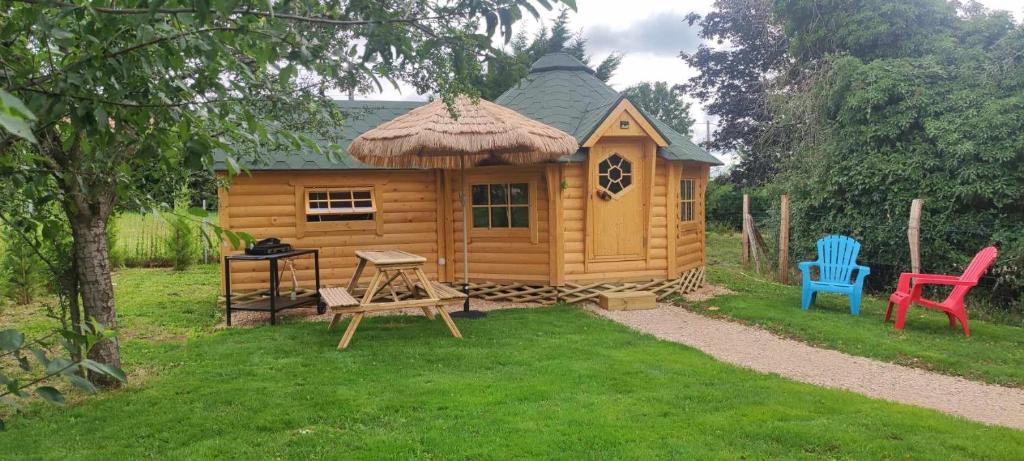 a small wooden cabin with two chairs and a table at Cabane Kota finlandais in Laives