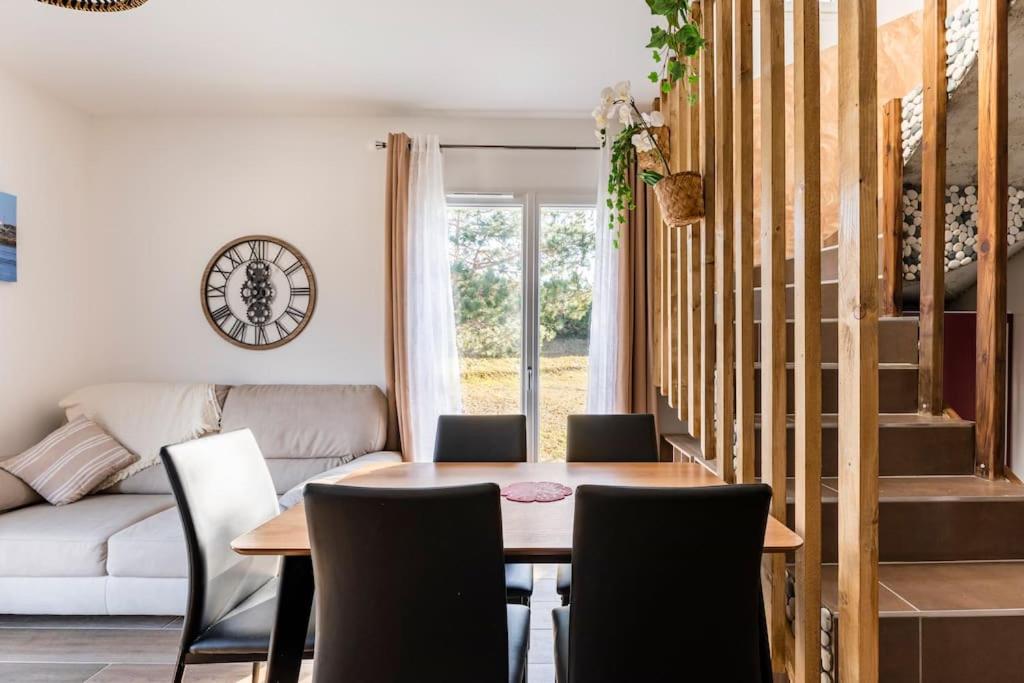 een eetkamer met een tafel, stoelen en een bank bij Appartement Maeva in Saint-Pée-sur-Nivelle