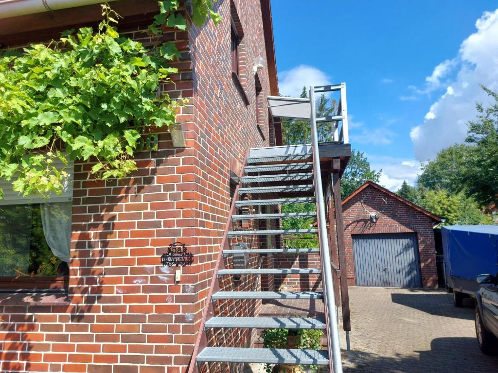 uma escada encostada a uma parede de tijolos ao lado de um edifício em Wruck,Ferienwohnung em Schneverdingen
