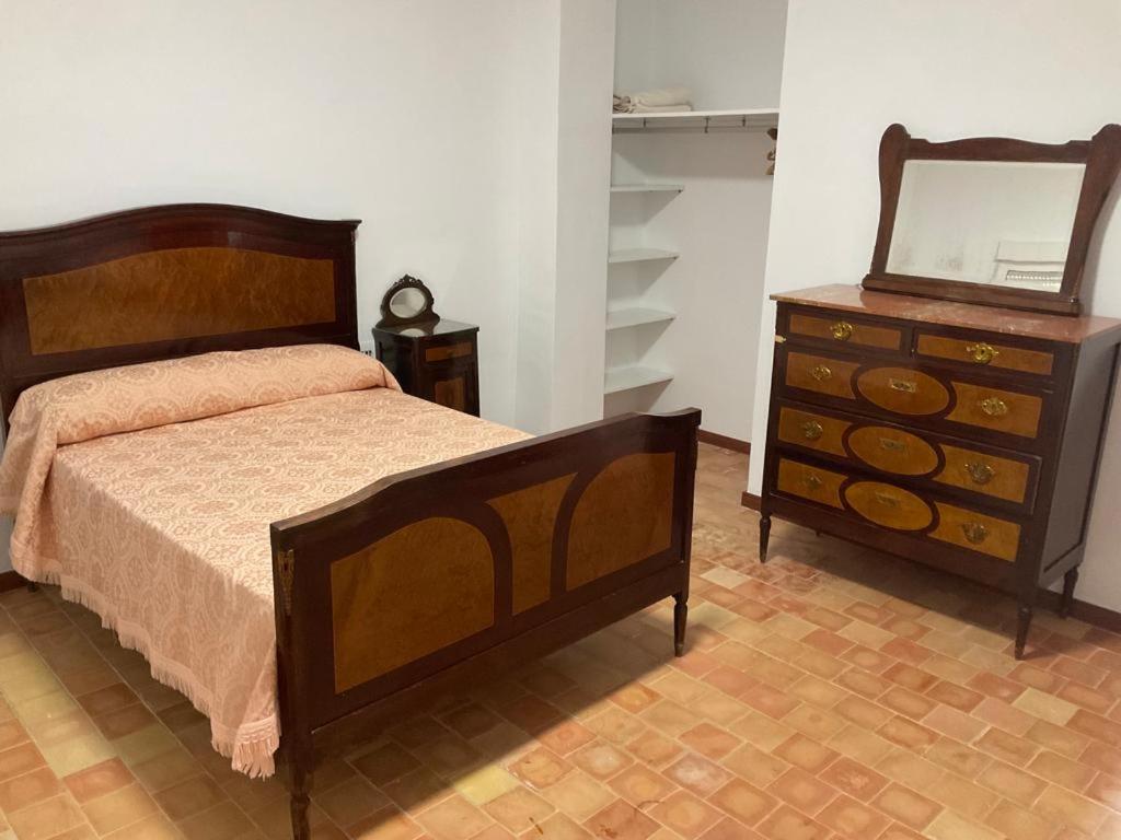 1 dormitorio con cama, tocador y espejo en Ca La Rubia en Benifairó de Les Valls