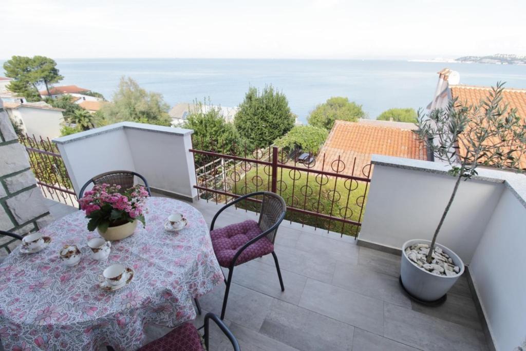 a table on a balcony with a view of the ocean at Apartment Zeljka in Crveni Vrh