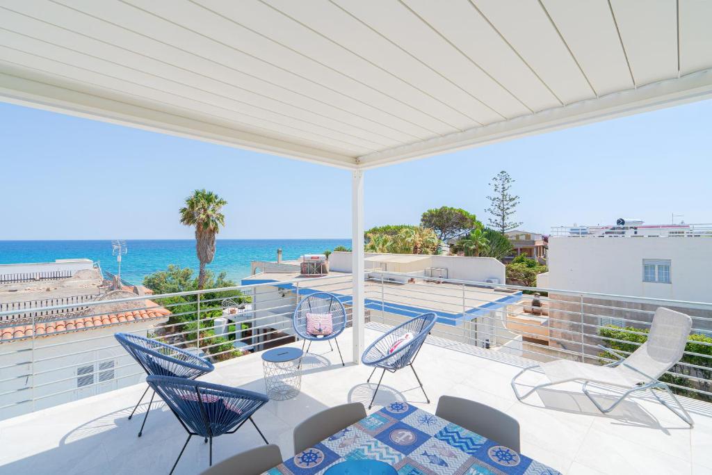 Un balcón con sillas y vista al mar. en Appartamento Greta vista mare, en Marina di Noto