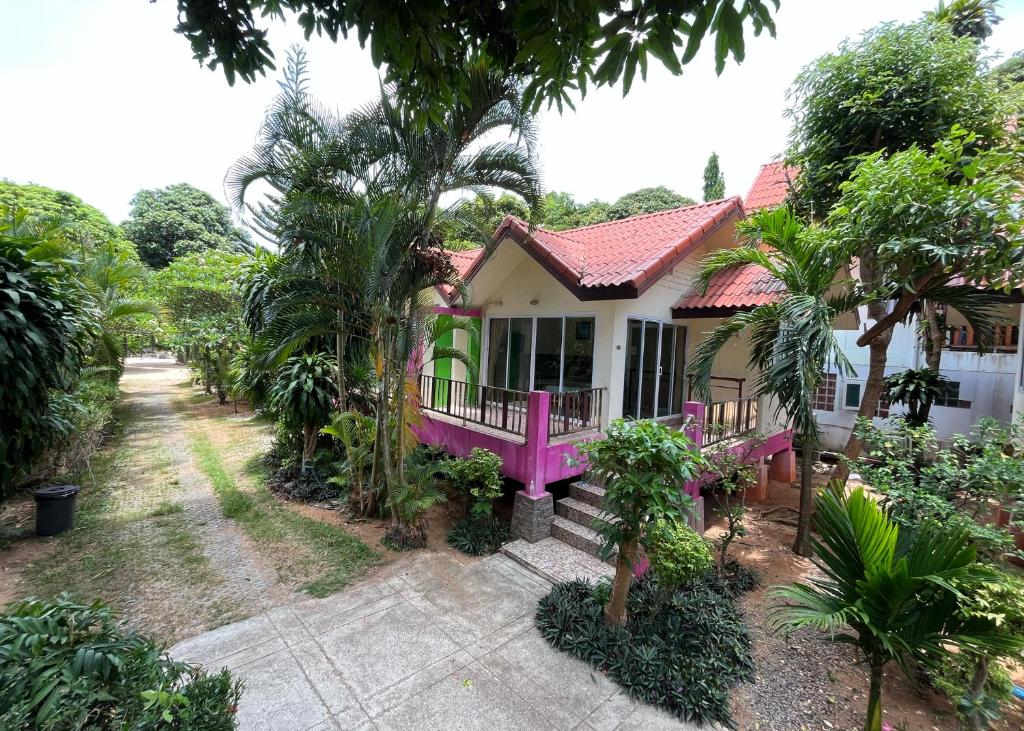 a pink house in the middle of a garden at Mae Somboon House in Lamai
