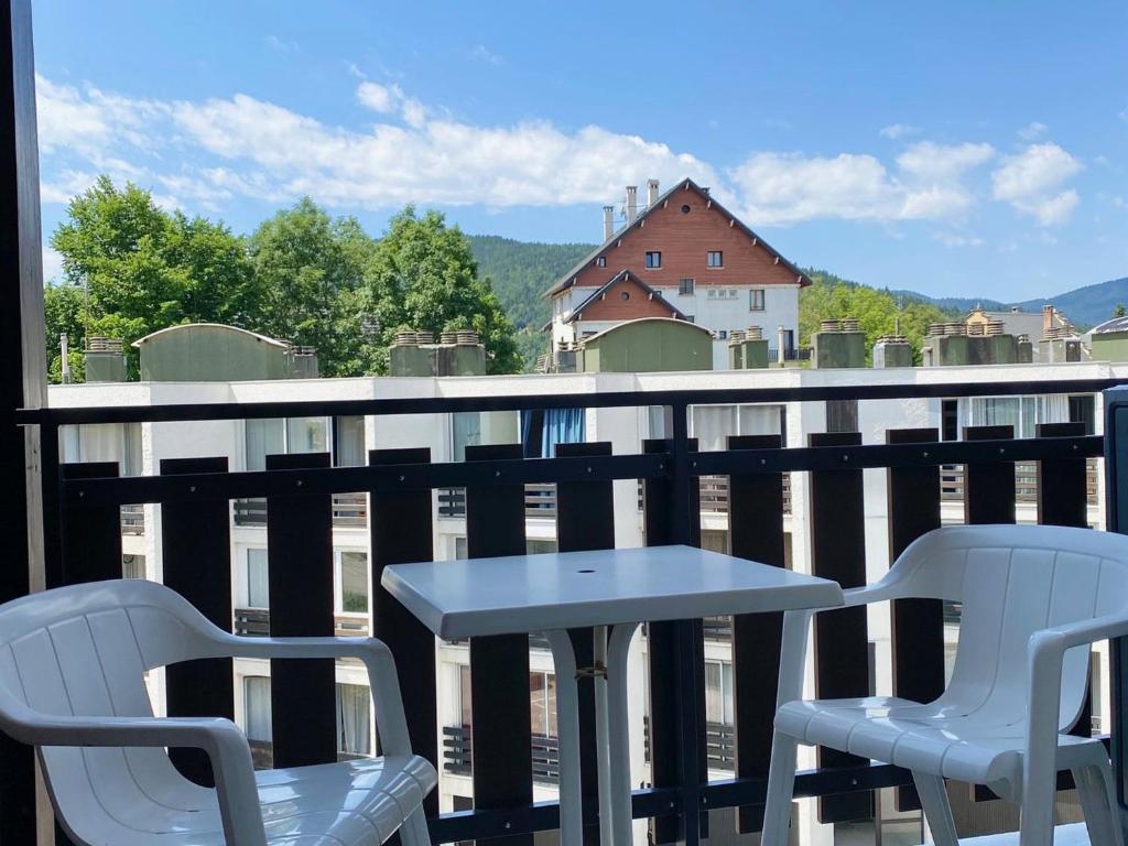 deux chaises et une table sur un balcon dans l'établissement Studio cabine rénové 4 pers. proche centre avec balcon et cuisine équipée - FR-1-689-80, à Villard-de-Lans