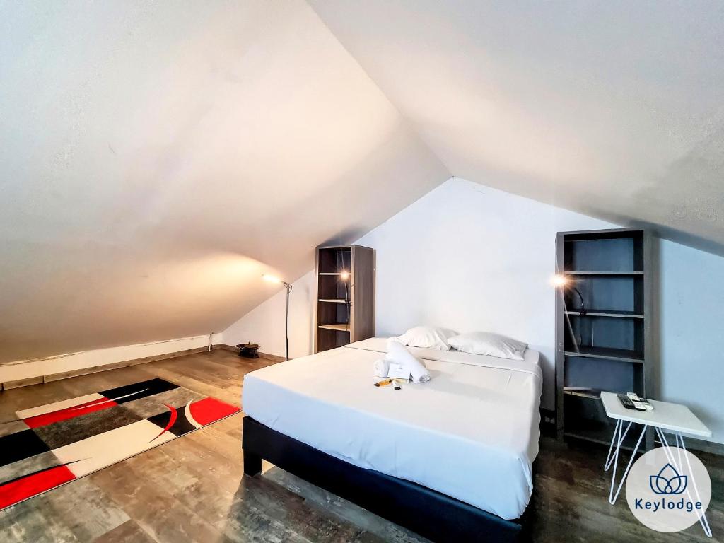 um quarto com uma cama branca e uma secretária em Corail- Duplex de 45m2 - 10 min de l'aéroport et du centre de Saint Denis em Saint-Denis