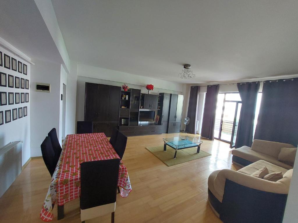 una sala de estar con una mesa y un sofá en Roxana apartament 3 camere, en Râmnicu Vâlcea