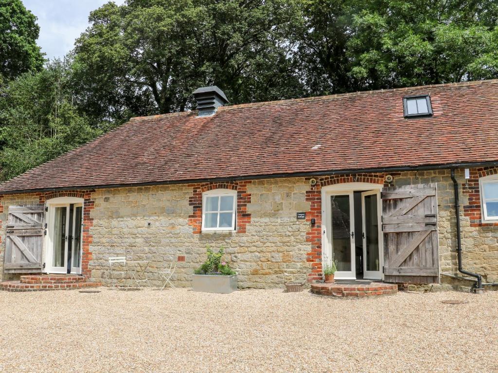 a small brick house with a window and a roof at Hungers Cottage in Petworth