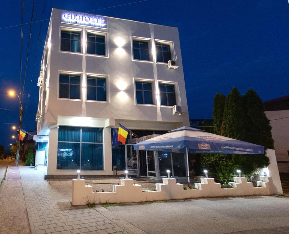 un edificio con una sombrilla delante de él en Hotel Duet, en Piteşti
