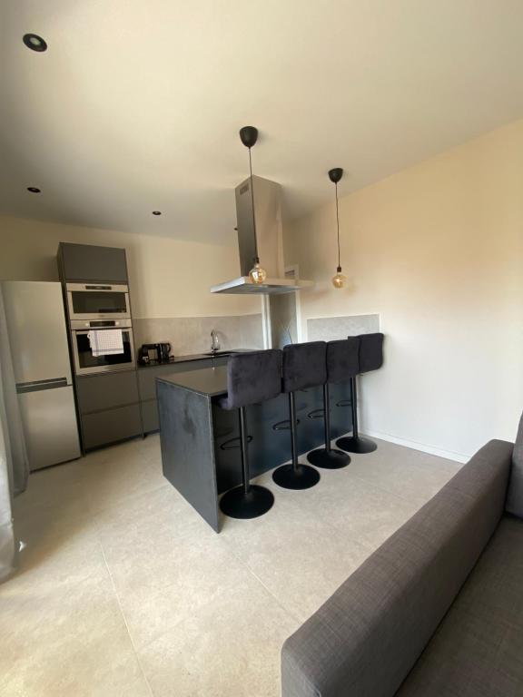 a kitchen with a bar with stools and a counter at Résidence Le Provence in Le Lavandou