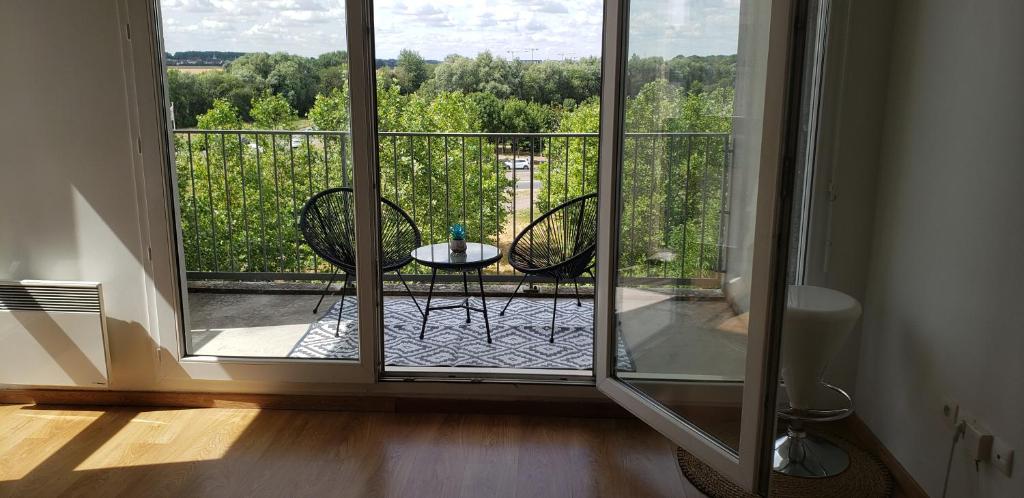 um quarto com uma varanda com uma mesa e cadeiras em Prague apartment in Disneyland em Montévrain