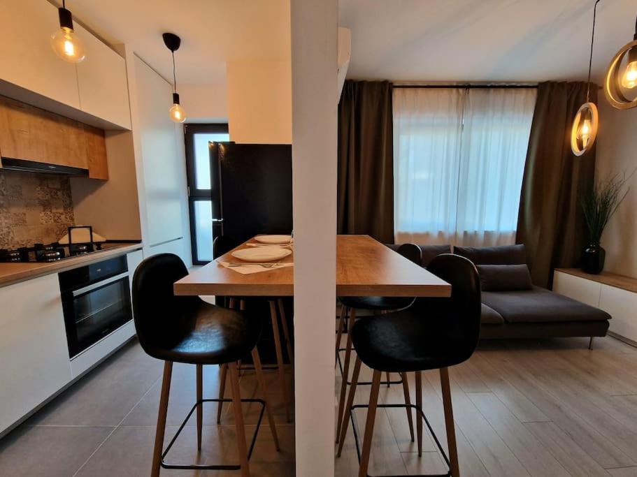cocina y sala de estar con mesa y sillas en Onix - Nordic Studio Apartment 3, Premium Parking en Bucarest