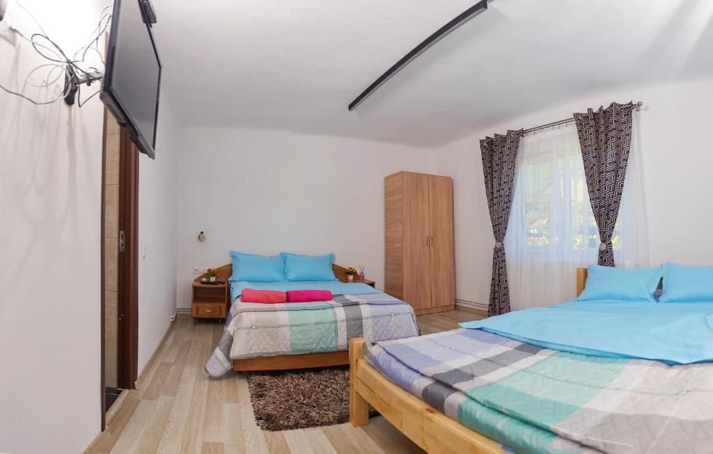 a bedroom with two beds and a flat screen tv at Carla House in Vidolm