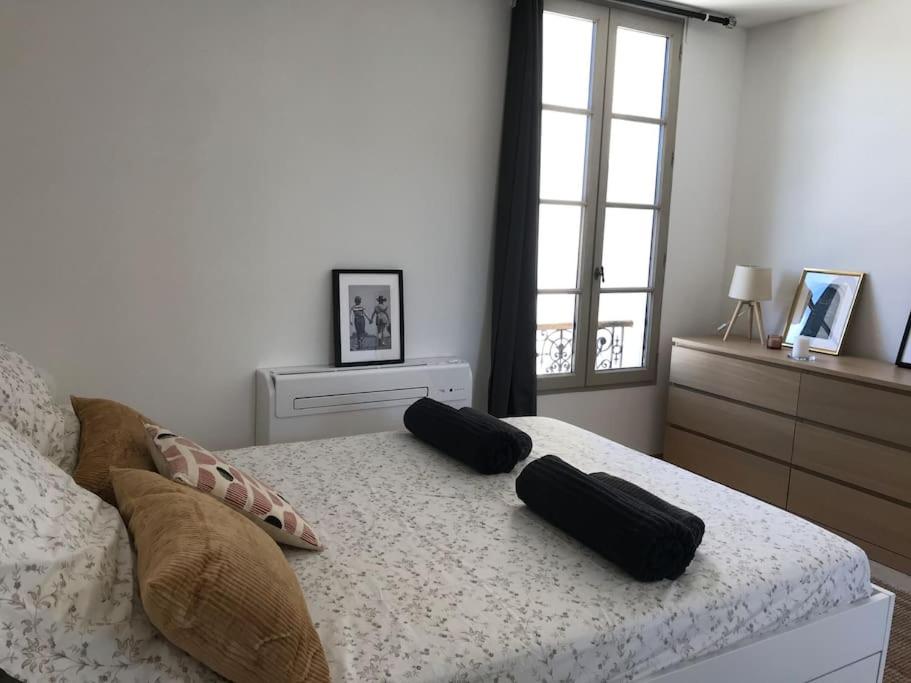 ein Schlafzimmer mit einem Bett mit zwei Kissen darauf in der Unterkunft La Maison Racine 4 - Cocon en plein centre ville in Avignon