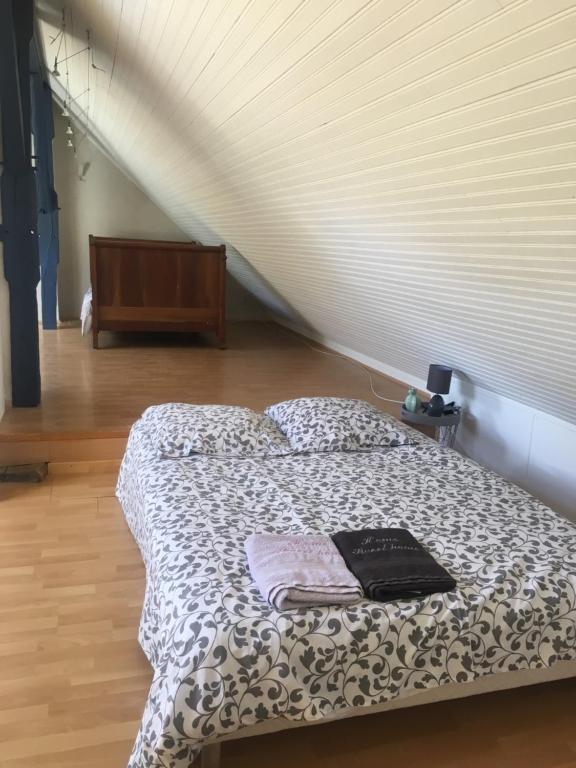 um quarto com uma cama com um livro em Le Valon em Blou