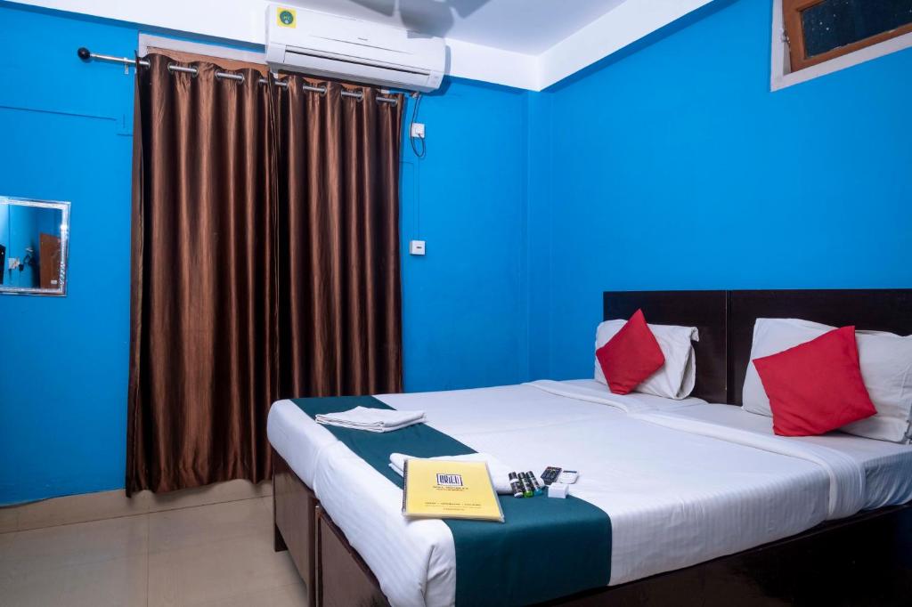 Una habitación azul con una cama con un libro. en Shree Krishna GH en Guwahati