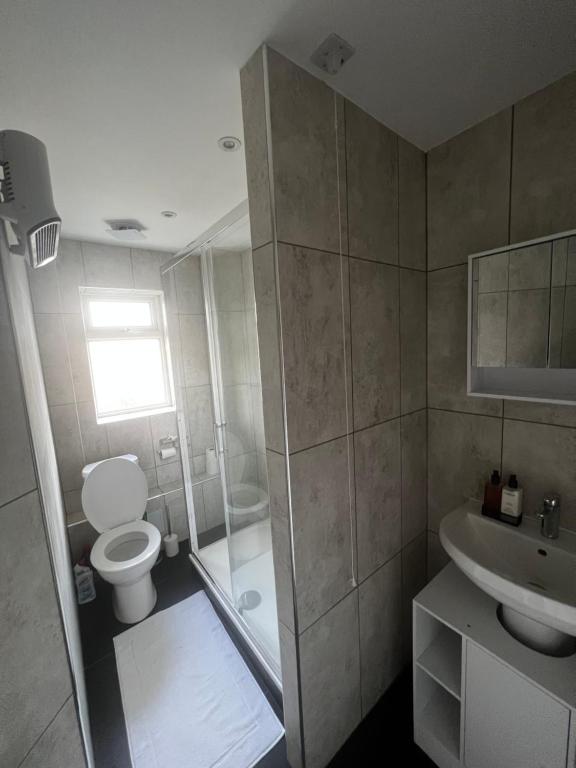 Lovely 2-Bed Apartment in Grays في South Ockendon: حمام مع مرحاض ودش ومغسلة