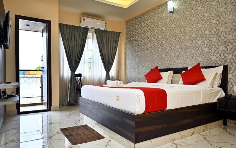 a large bedroom with a large bed with red pillows at SB Golden Cherry in Yelahanka