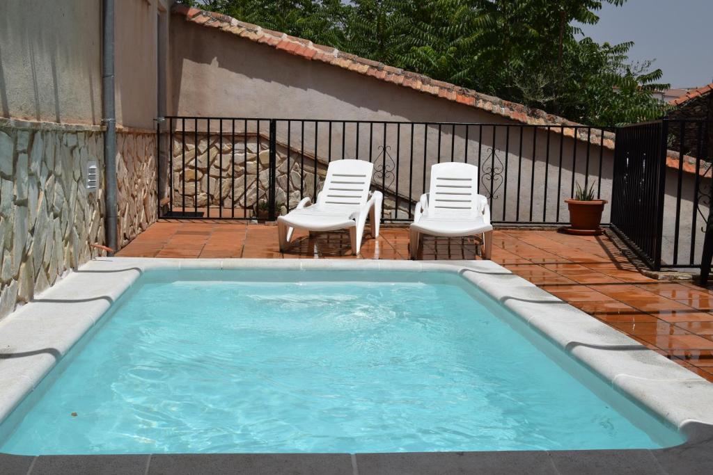 2 sillas de césped y una piscina con 2 sillas en Casa rural Batalla Navas de Tolosa, Despeñaperros, en Santa Elena