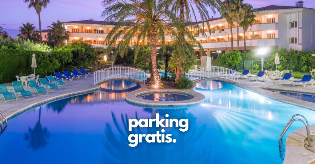 uma piscina de resort com uma palmeira e as palavras estacionamento grátis em Mas Gallau em Cambrils