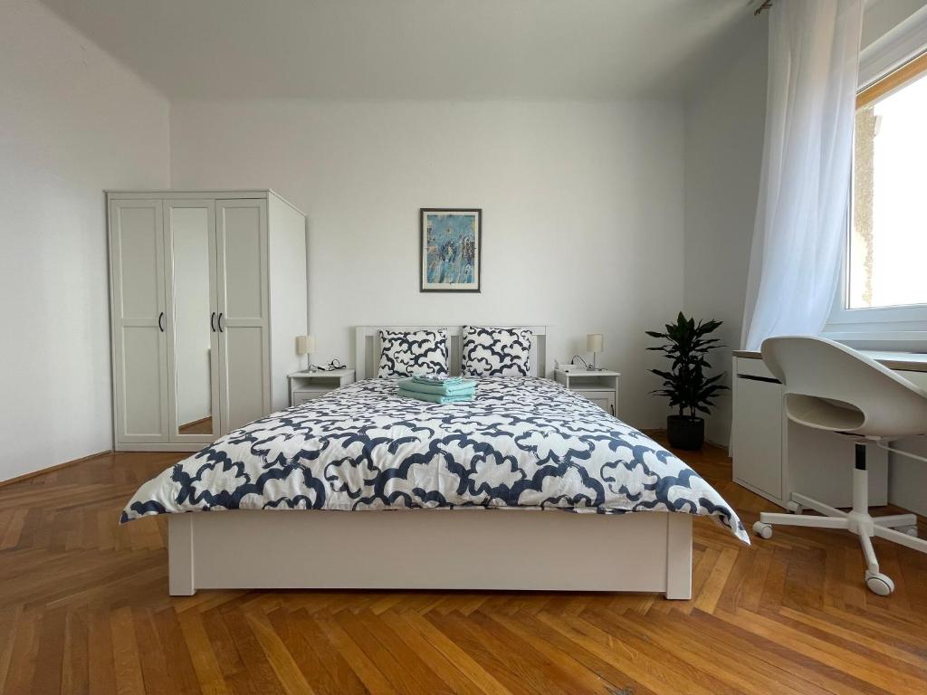 a white bedroom with a bed and a desk at Nona's view with balcony in Rijeka