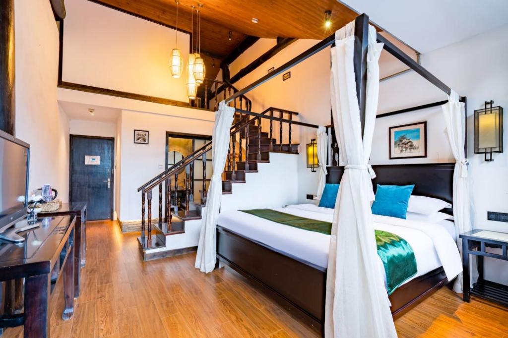 蘇州的住宿－天易居客栈(苏州同里古镇店)，一间卧室设有一张床和一个楼梯