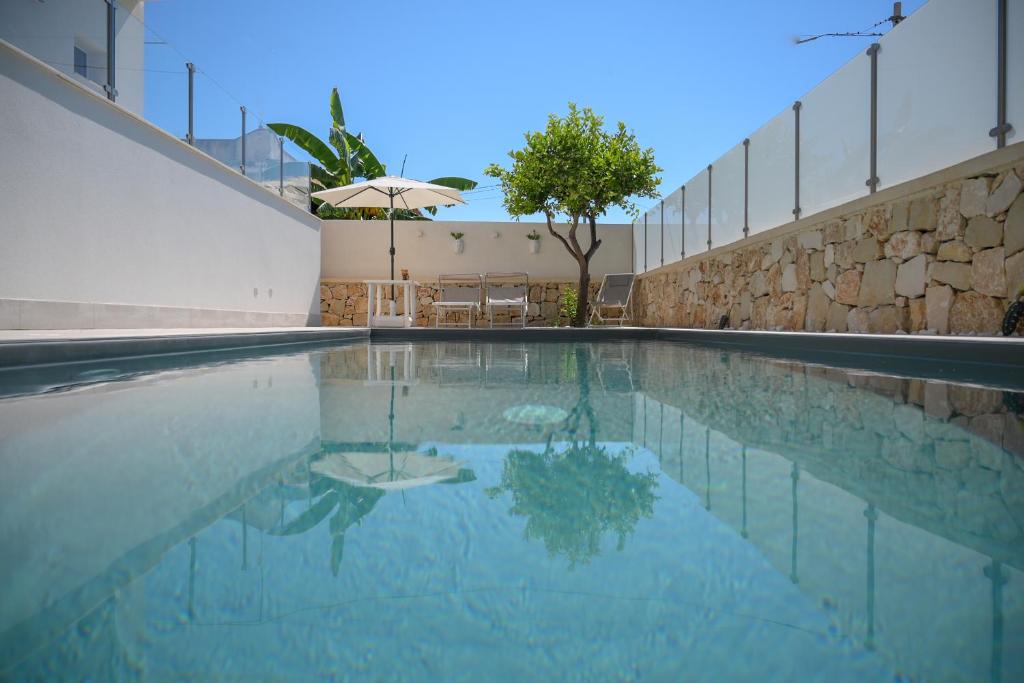 an empty swimming pool with an umbrella in a building at Villa Carlotta con piscina in Noto Marina