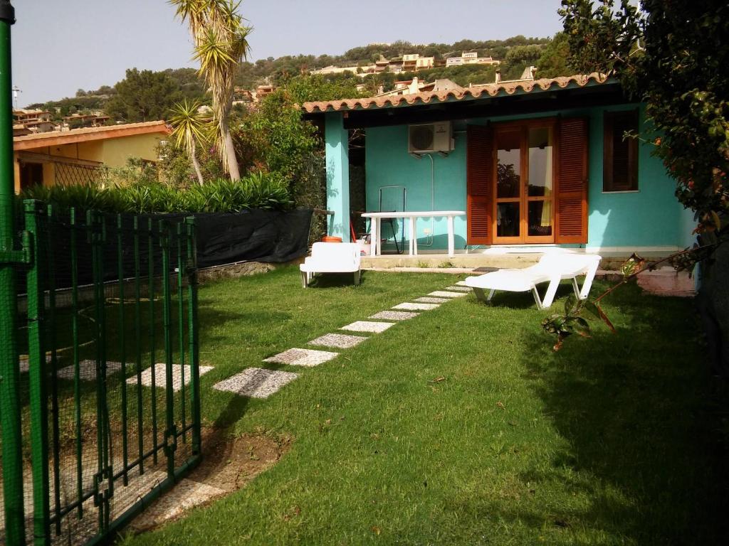 una casa blu con una panchina nel cortile di Casa Gianfabio a Costa Rei