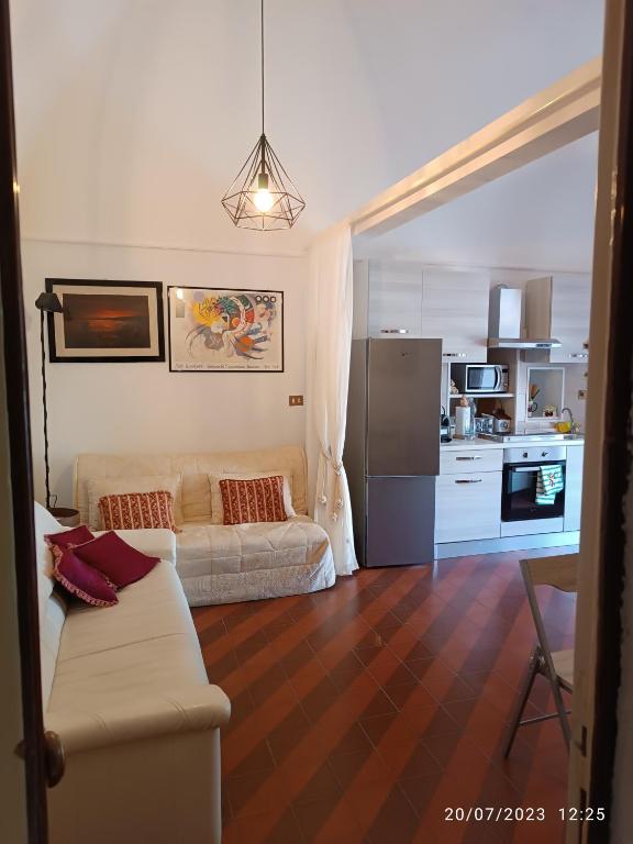 ein Wohnzimmer mit einem Sofa und einer Küche in der Unterkunft Locazione turistica La vecchia arcata in Noci