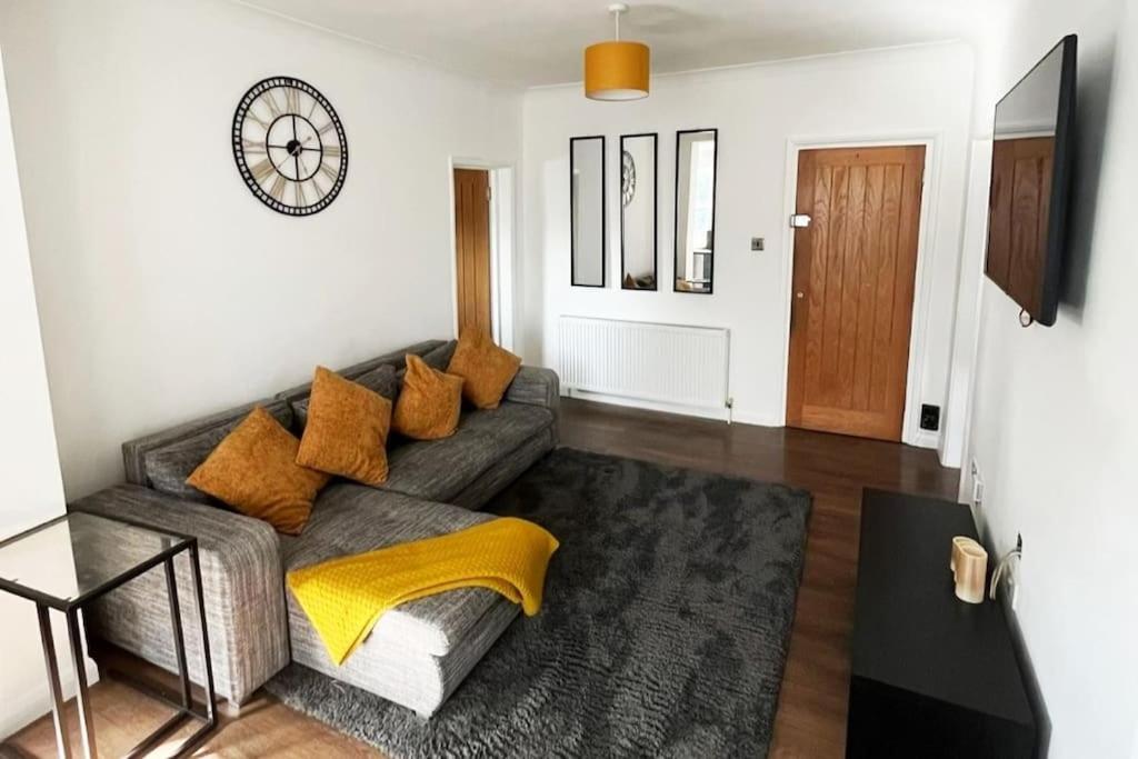a living room with a gray couch with yellow pillows at Luxury, Spacious 1 Bedroom Flat in South Norwood
