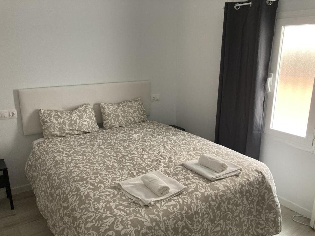 a bedroom with a bed with two towels on it at Casa de Huéspedes Cinco Torres in Madrid
