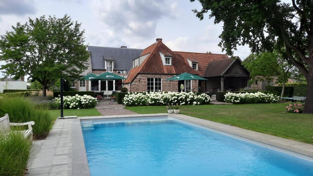 una casa con piscina di fronte a una casa di Vakantiehuis Rosselaer a Balen
