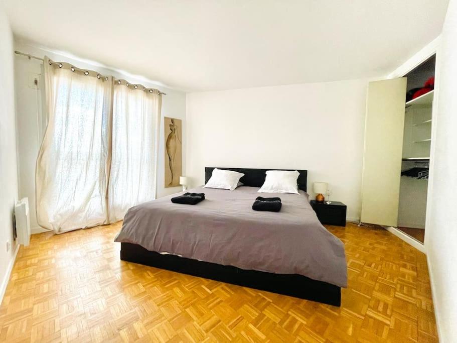 a bedroom with a large bed and a wooden floor at Beautiful apartment with Eiffel tower view in Puteaux