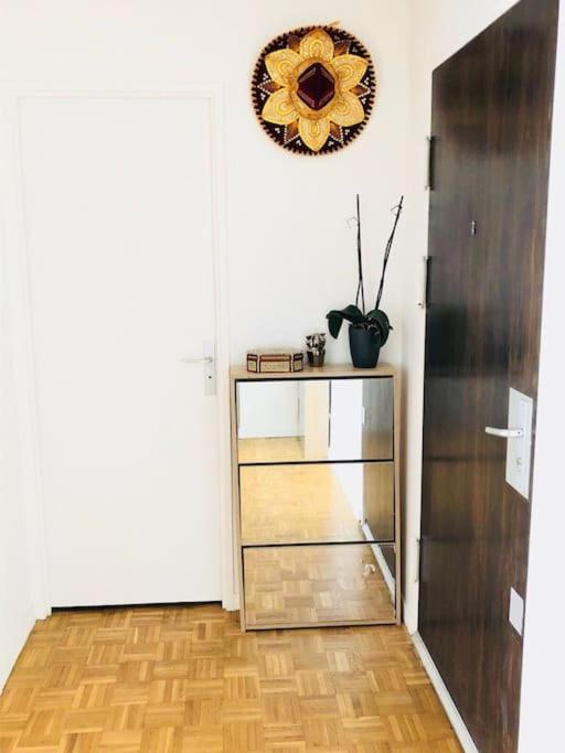 a room with a dresser with a flower on the wall at Beautiful apartment with Eiffel tower view in Puteaux