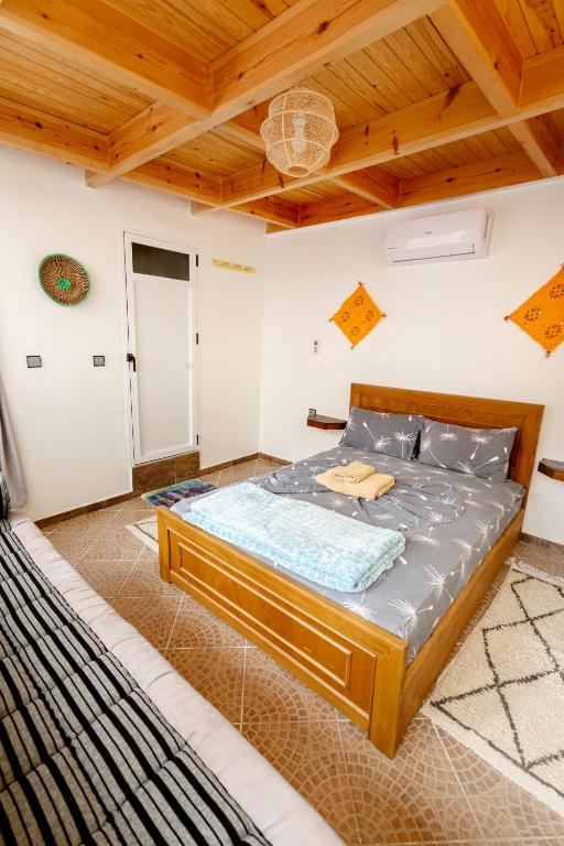a bedroom with a bed in a room with wooden ceilings at The Rina Hostel in Agadir