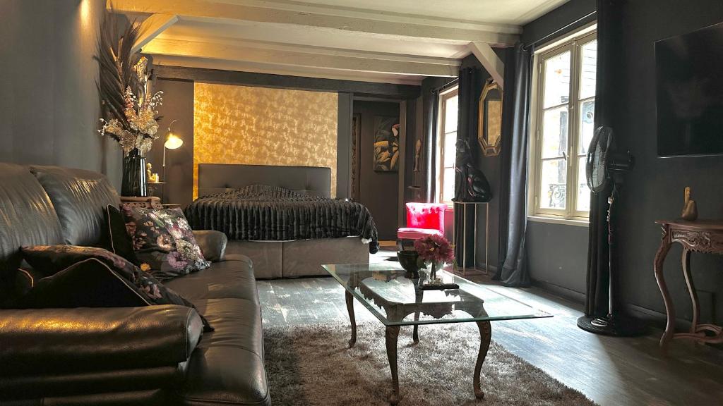 sala de estar con sofá y cama en LA BLACK ROOM / Les suites romantiques à Honfleur centre historique, en Honfleur
