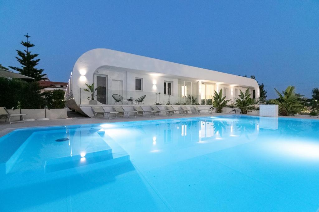 a large swimming pool in front of a white house at Stellaris Apartrooms in Termoli