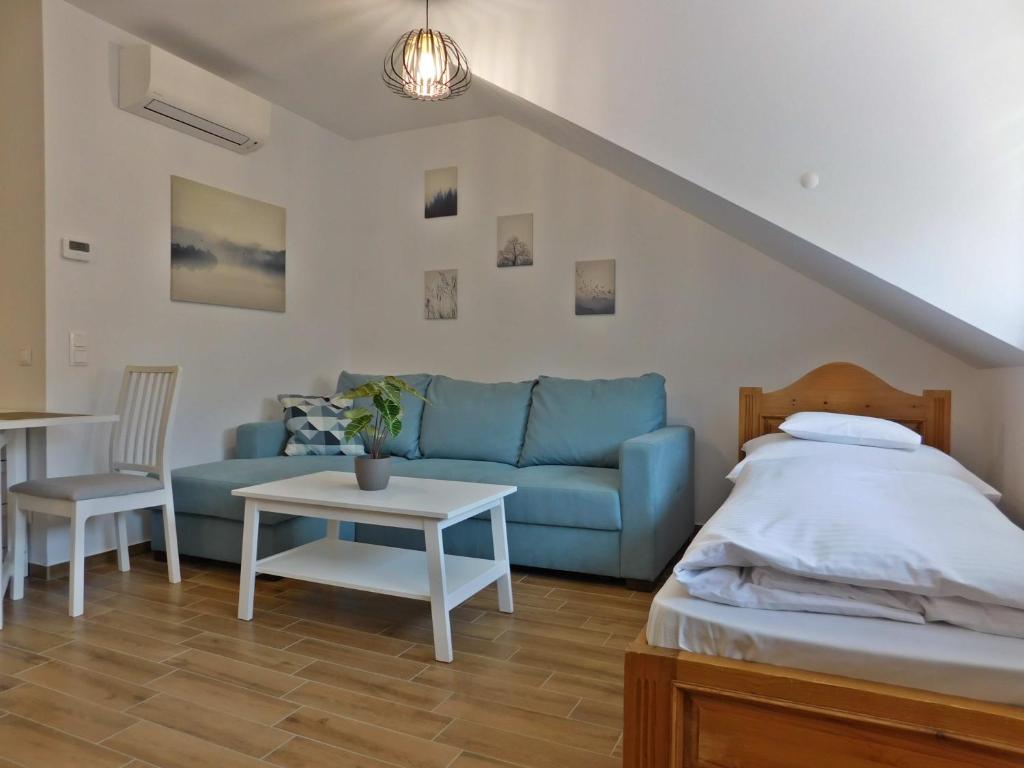 sala de estar con sofá azul y mesa en Berki Apartman, en Körmend