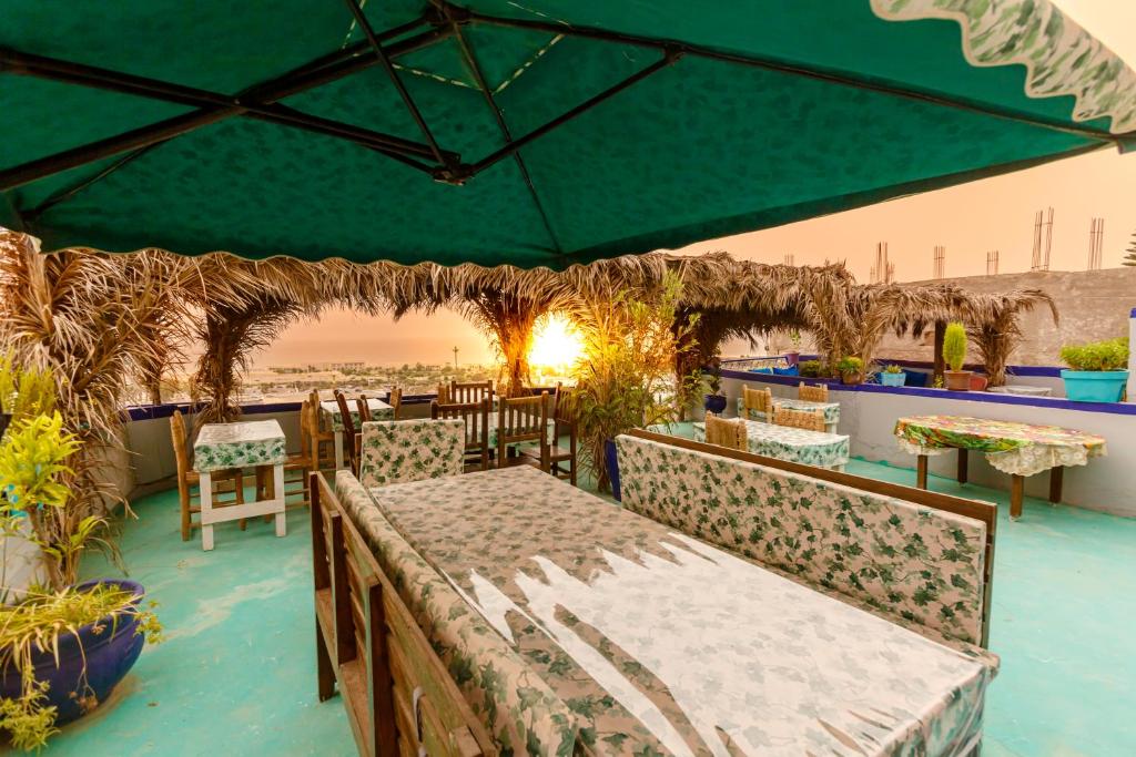 a patio with a table and chairs on the beach at The Rina Hostel in Agadir