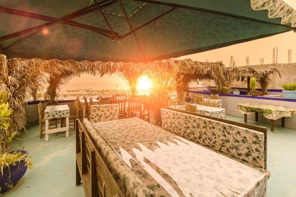 a patio with a table and chairs with the sun setting at The Rina Hostel in Agadir