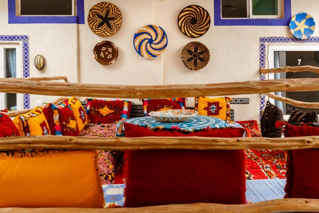 a room with colorful pillows on a wall with a table at The Rina Hostel in Agadir