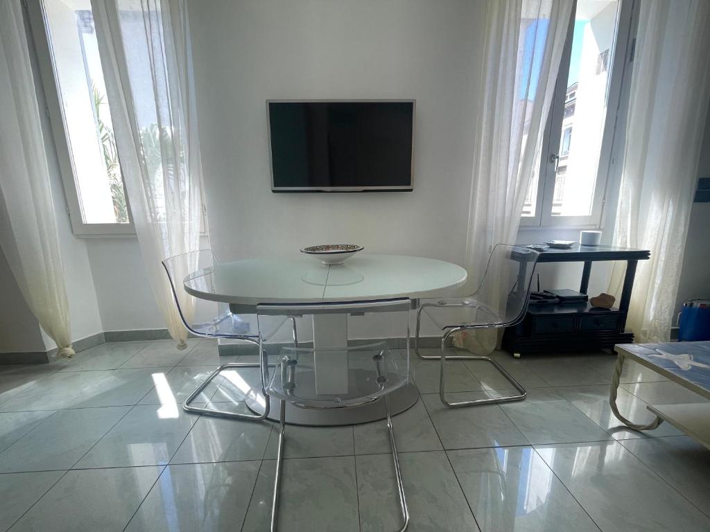 Cette chambre blanche dispose d'une table et d'une télévision murale. dans l'établissement 50 Mètres du Palais by Connexion, à Cannes