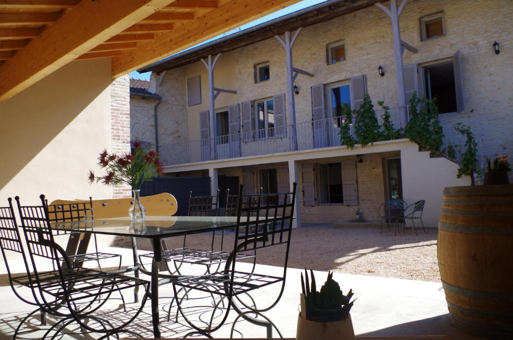 een patio met een tafel en stoelen voor een gebouw bij La maison de Michelle in Lugny