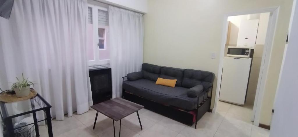 a living room with a black couch and a table at Departamento Las Heras in Mar del Plata