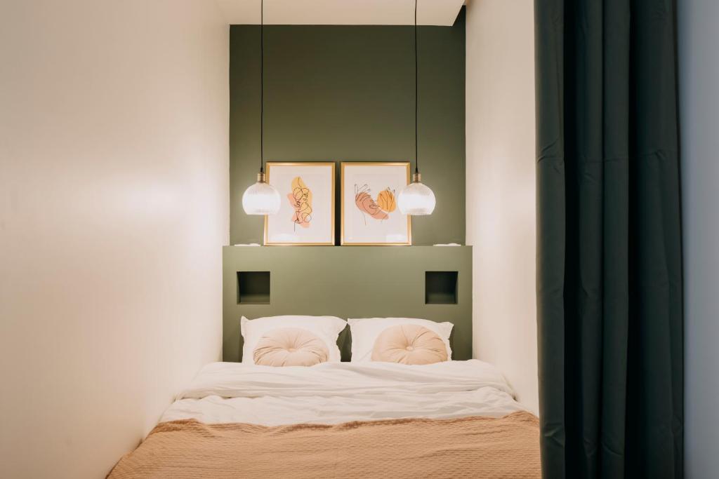 une chambre avec un lit et deux tableaux au mur dans l'établissement Bel écrin sur l'île de Nantes - GARE TGV, CHU, CONGRES, à Nantes