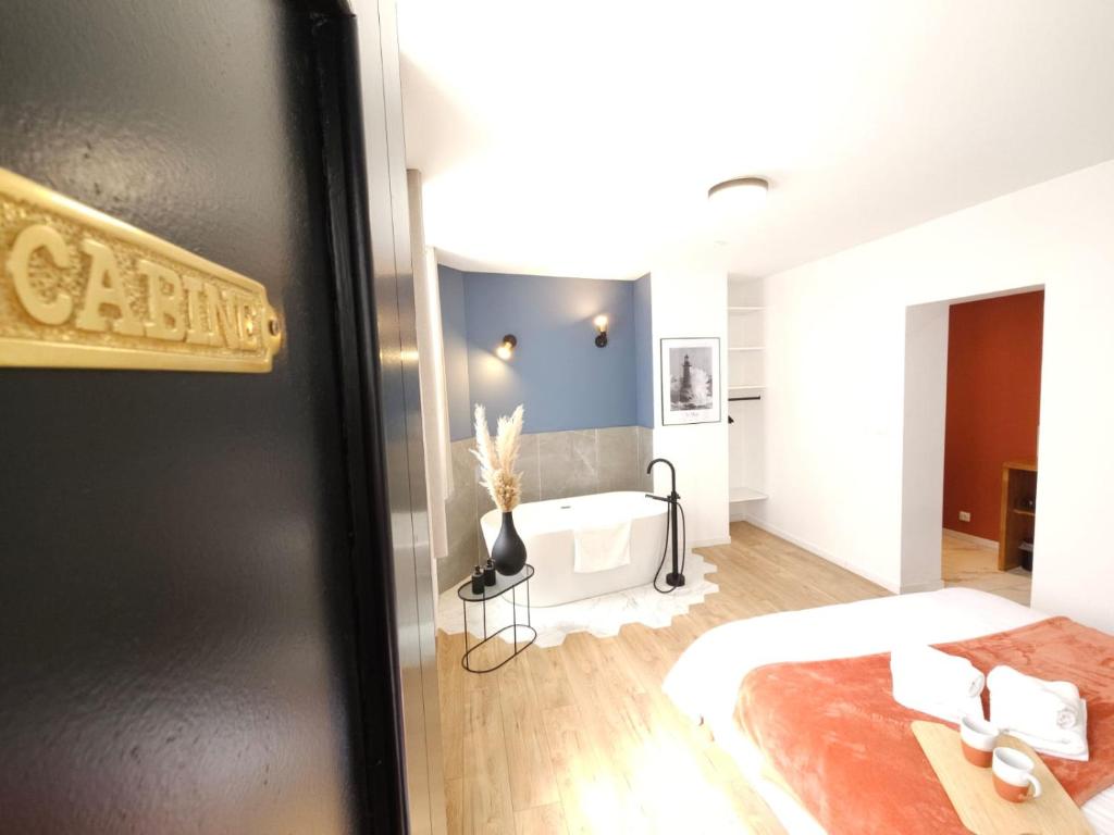 a bedroom with a bed and a tub in a room at Le Quai Victoire - L'Avenue des Voyageurs Cote d'Opale in Boulogne-sur-Mer