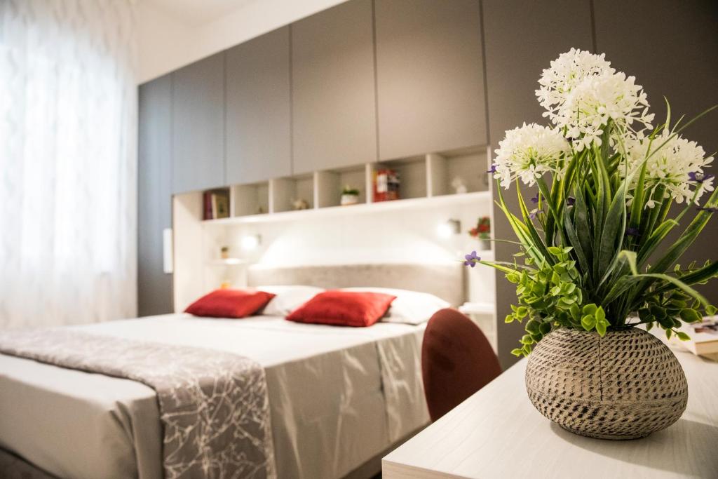 een slaapkamer met een bed en een vaas met bloemen op een tafel bij La casa di Ari in Napels