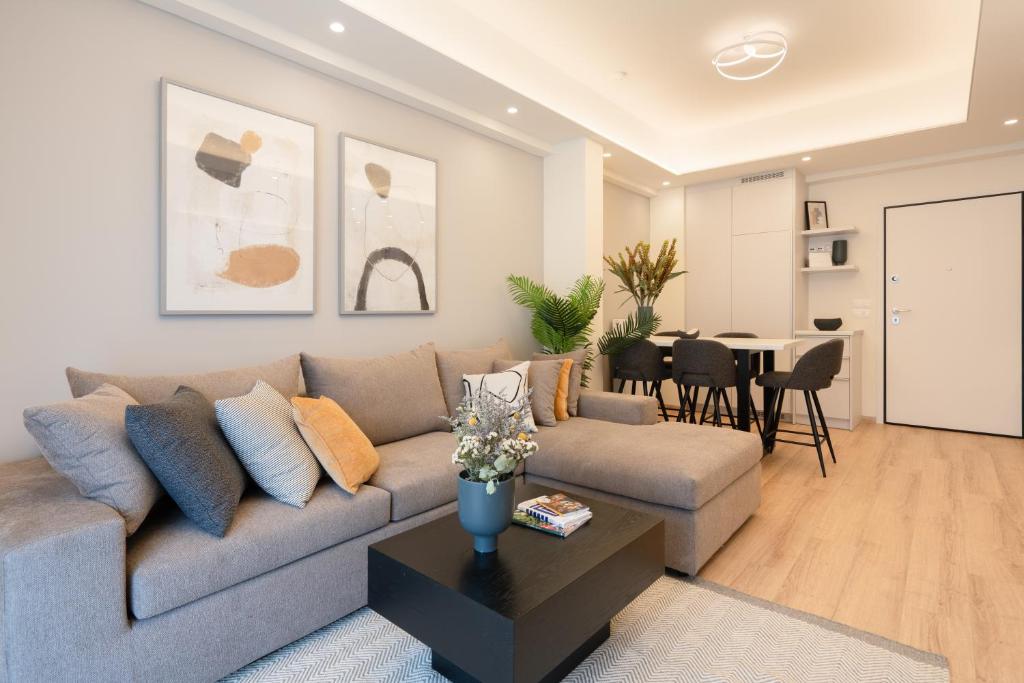 een woonkamer met een bank en een tafel bij Newly Renovated 2 Bedroom Apartment, 5min to metro in Athene