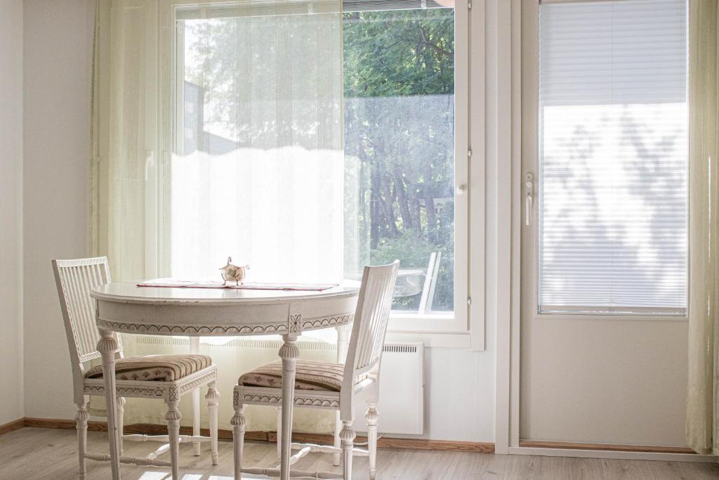 tavolo e sedie in una stanza con finestra di Santa's Row house a Rovaniemi