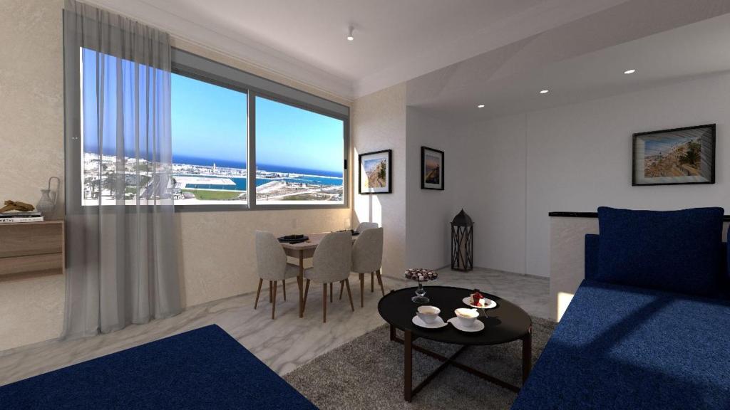 een woonkamer met een blauw bed en een tafel bij Appartement de Prestige, vue Kasbah, Mer et Vieux Port in Tanger