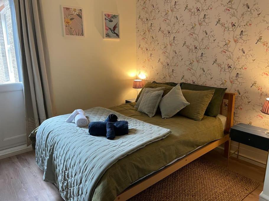 Un dormitorio con una cama con dos ositos de peluche. en West London stunning garden flat - period features en Londres